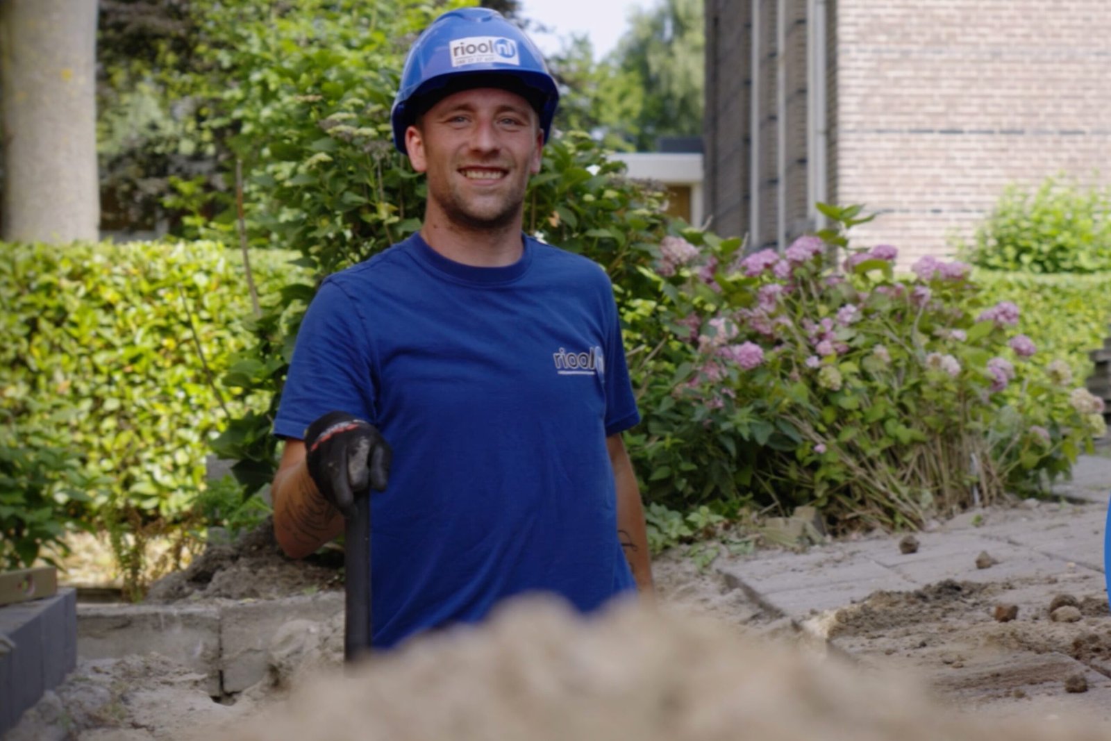 WerkenbijRioolnl - Grondwerker die een put aan het stellen is